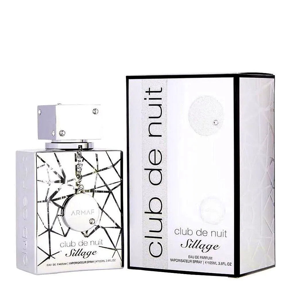 Eine schlanke, moderne Flasche von Armaf Club de Nuit Sillage Eau de Parfum Mixte, die eine silberne Kappe und ein abgestuftes blaues Glasdesign aufweist, das auf einem minimalistischen Hintergrund ruht.