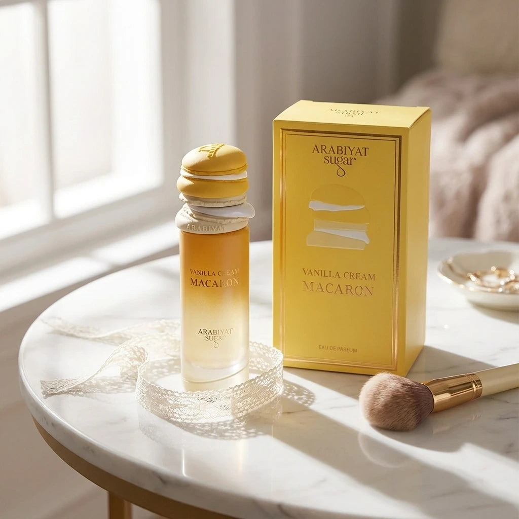 High-end lifestyle e-commerce photography of the Arabiyat Sugar Vanilla Cream Macaron perfume bottle resting on a smooth white marble vanity table. Next to it, a delicate white lace ribbon and a luxury gold-trimmed makeup brush. Soft morning sunlight streams through a window, casting long, elegant geometric shadows across the scene. Romantic, clean girl aesthetic, cozy and highly premium. Aspect ratio 1:1, size 1200x1200px. (gemini-3.1-flash-image-preview)