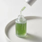 High-end commercial cosmetic photography of the Celimax Noni Energy Ampoule. The bottle is placed on a smooth, matte white ceramic surface. The dropper is extracted and held just above the bottle opening, with one single, clear, slightly viscous drop of the liquid serum about to fall. Soft, diffused studio lighting creating gentle shadows. Minimalist aesthetic. Shot on 70mm lens, F7 aperture, ISO 250. Photorealistic, macro details, ultra-sharp focus on the drop. --ar 1:1 (gemini-3-pro-image-preview)