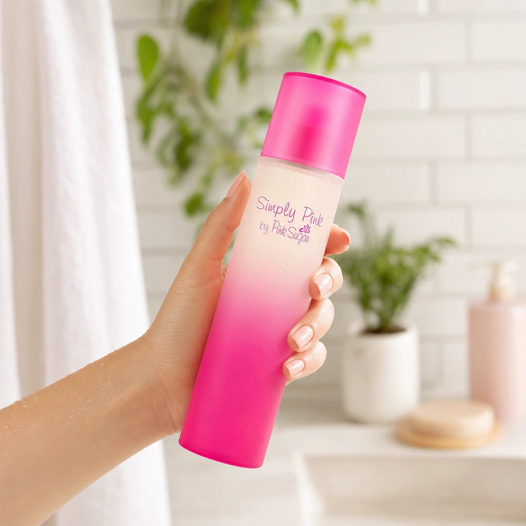 Scène : Photographie de style lifestyle. Une main féminine soignée tient délicatement le flacon "Simply Pink by Pink Sugar", s'apprêtant à l'utiliser après une douche. La main est positionnée naturellement. La lumière est douce et flatteuse.  Angle : Prise de vue à niveau, légèrement oblique.  Fond : Une salle de bain minimaliste floue, avec des carreaux de métro blancs et des plantes vertes. (gpt-image-2)