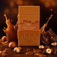 Creative e-commerce shot of the Arabiyat Sugar Toffee Ganache perfume bottle inspired by image_a2f04c.jpg. The bottle stands on a dark, polished wooden surface, surrounded by artistic splashes of thick, glossy liquid caramel, a few elegant swirls of chocolate ganache, and whole toasted hazelnuts scattered around. The background is a soft, warm, dark amber bokeh blur. Indulgent, luxurious, and deeply sweet fragrance concept. Aspect ratio 1:1, size 1200x1200px. (gpt-image-2)